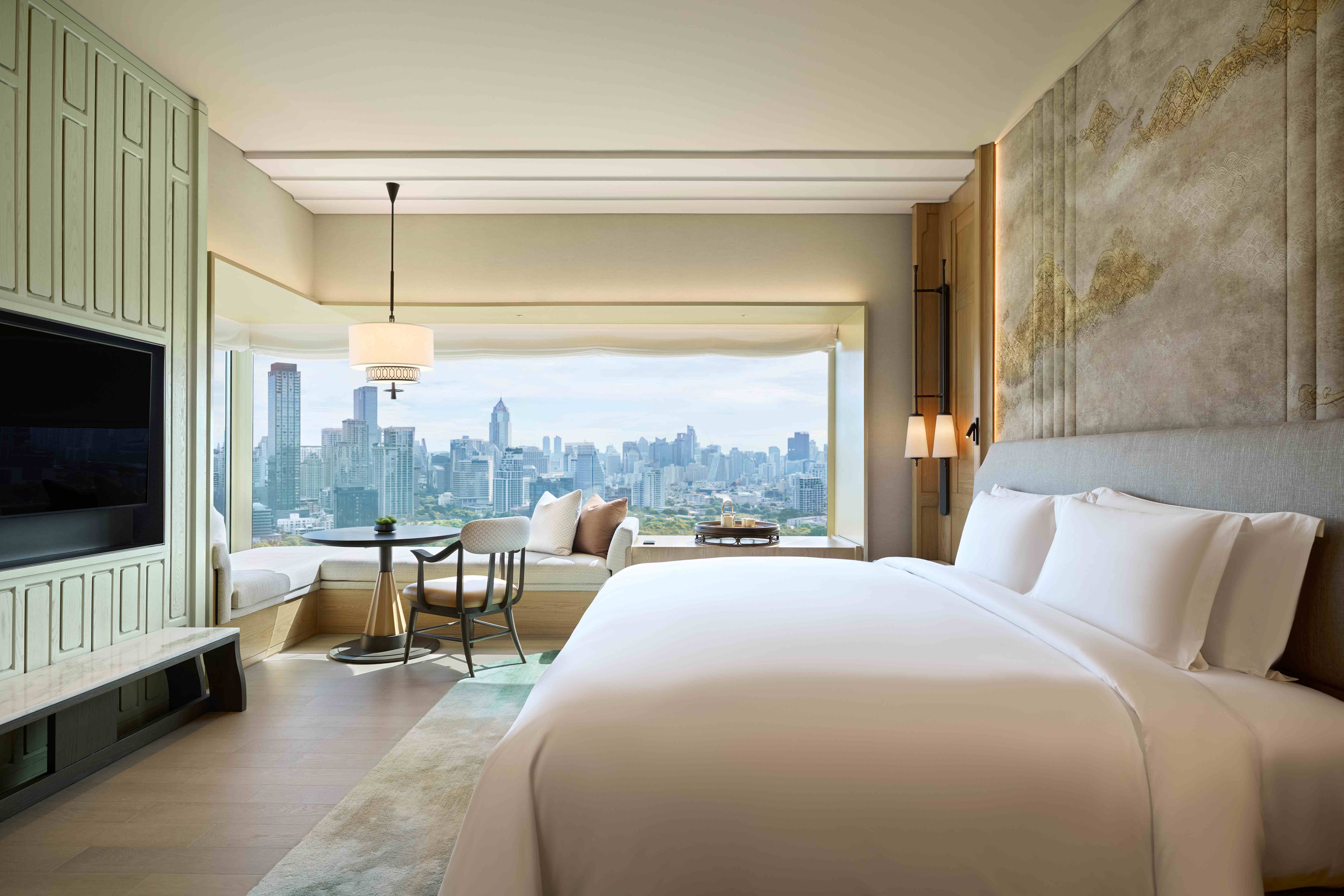 Each guest room at the reimagined Dusit Thani Bangkok offers refined comfort and panoramic views of Lumpini Park and the city skyline.